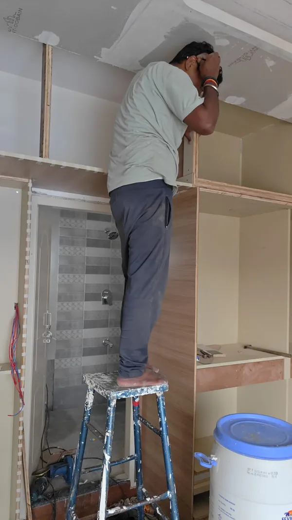Carpenter installing bespoke wardrobe carcass with Saint-Gobain gypsum ceiling framing
