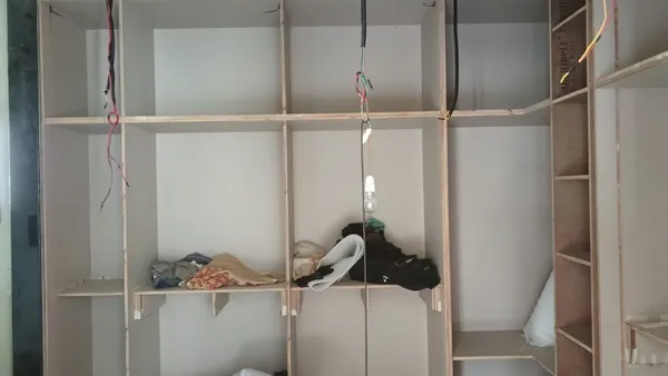 Open bookshelf structure integrated with corner window ledge and base storage compartments