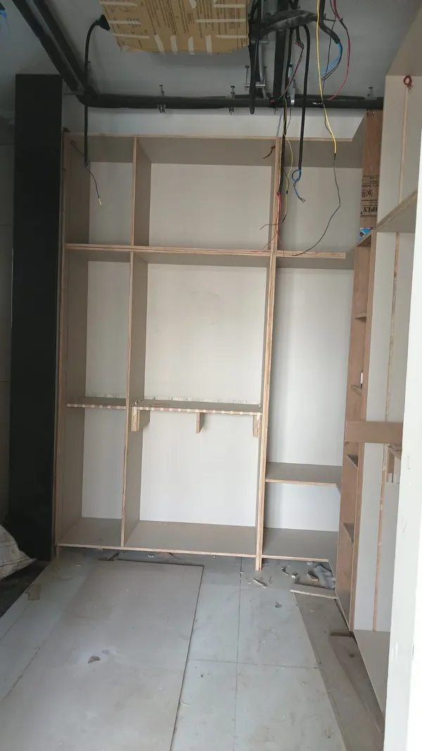 Vertical alignment check of tall 6-tier bookshelf carcass prior to final wall anchoring