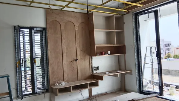 Custom wall installation featuring three arched plywood panels, floating media shelf, and study desk