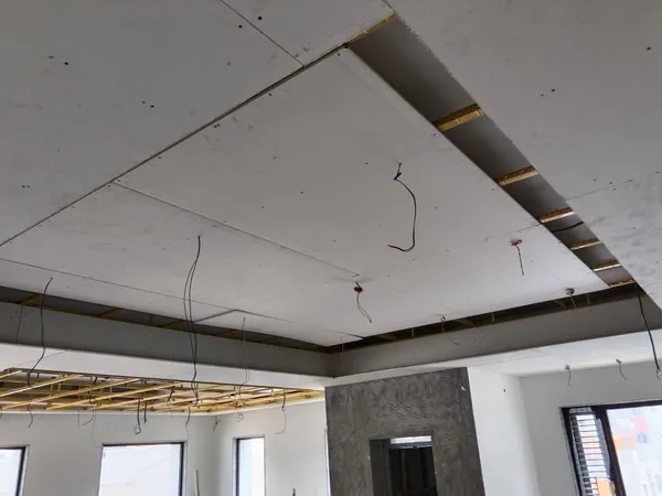 False ceiling metal framing spanning between bedroom and floor-to-ceiling glass balcony slider