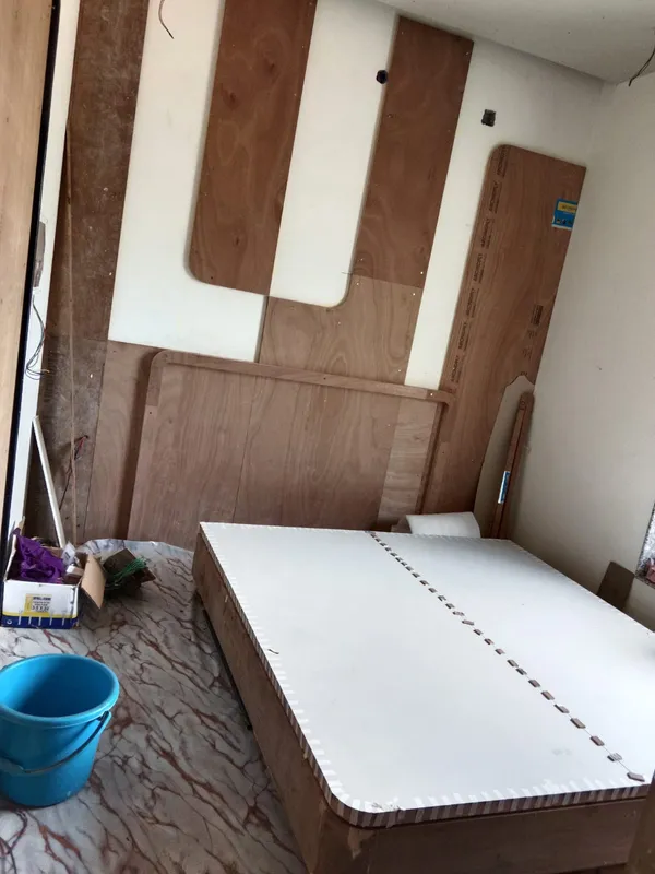 Curved headboard framing and finished white platform bed base assembled in bedroom